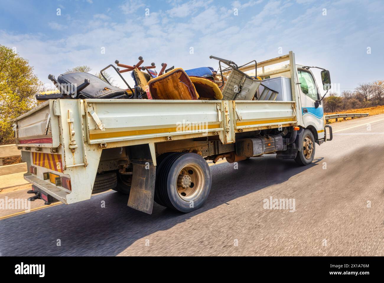 Großer Truck auf der Straße der Stadt, mit gebrauchten, kaputten Möbeln zum Recycling Stockfoto