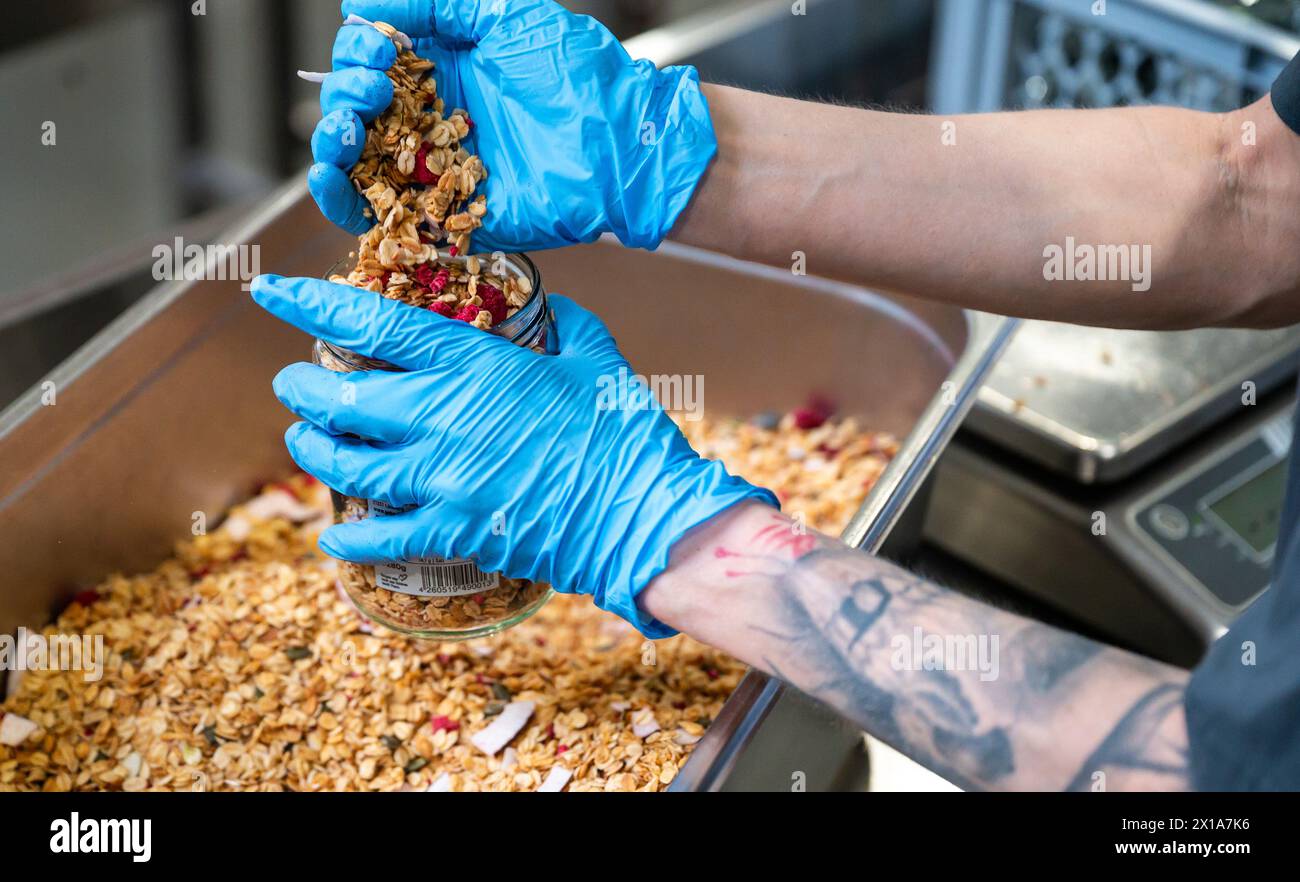 08. April 2024, Niedersachsen, Lüneburg: Müsli wird bei der HEYHO GmbH abgefüllt. Eine Karriere in Drogen oder Gefängnissen führt oft zu Arbeitslosigkeit. Ein Sozialunternehmen in Lüneburg will beweisen, dass es einen anderen Weg gibt. Foto: Philipp Schulze/dpa Stockfoto