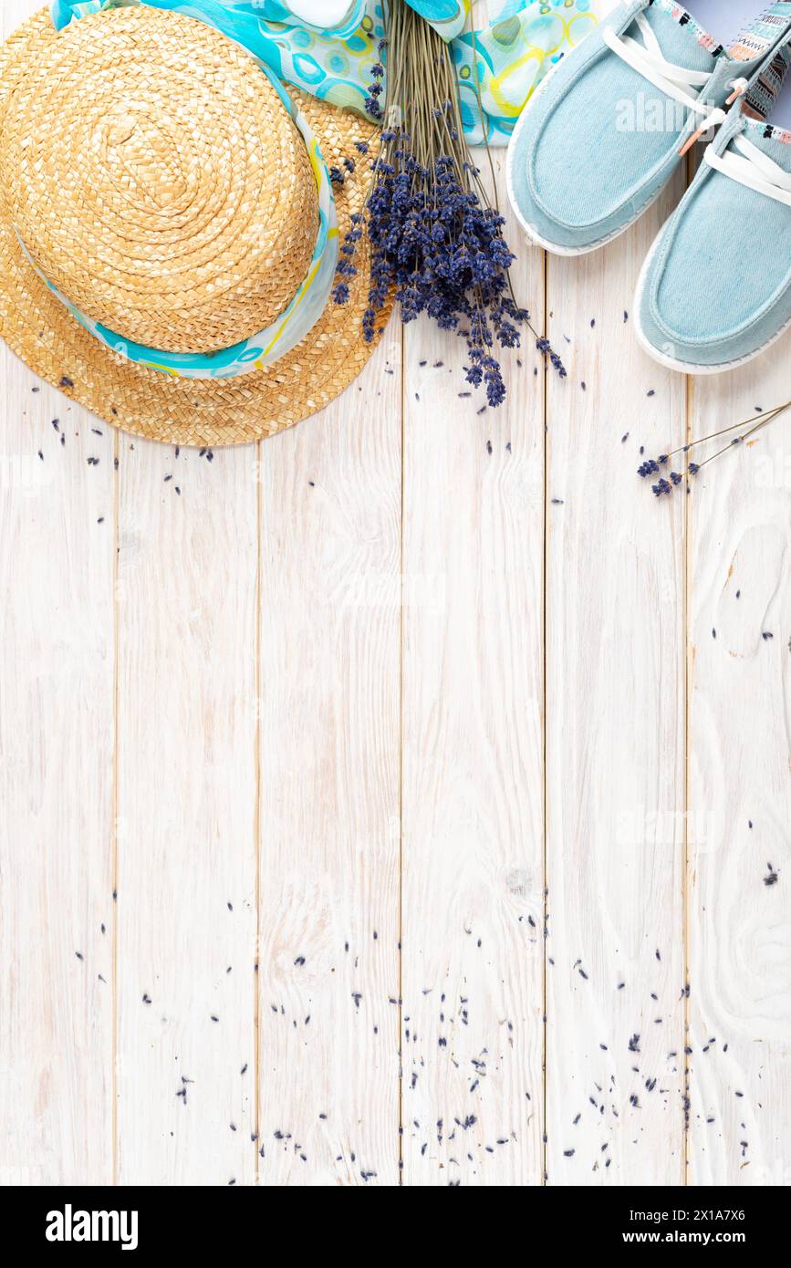 Strohhut, Lavendelblumen und Stoff-Mokassins auf weißen Dielen Urlaubsplanung Hintergrund flach gelegt mit Kopierraum Stockfoto