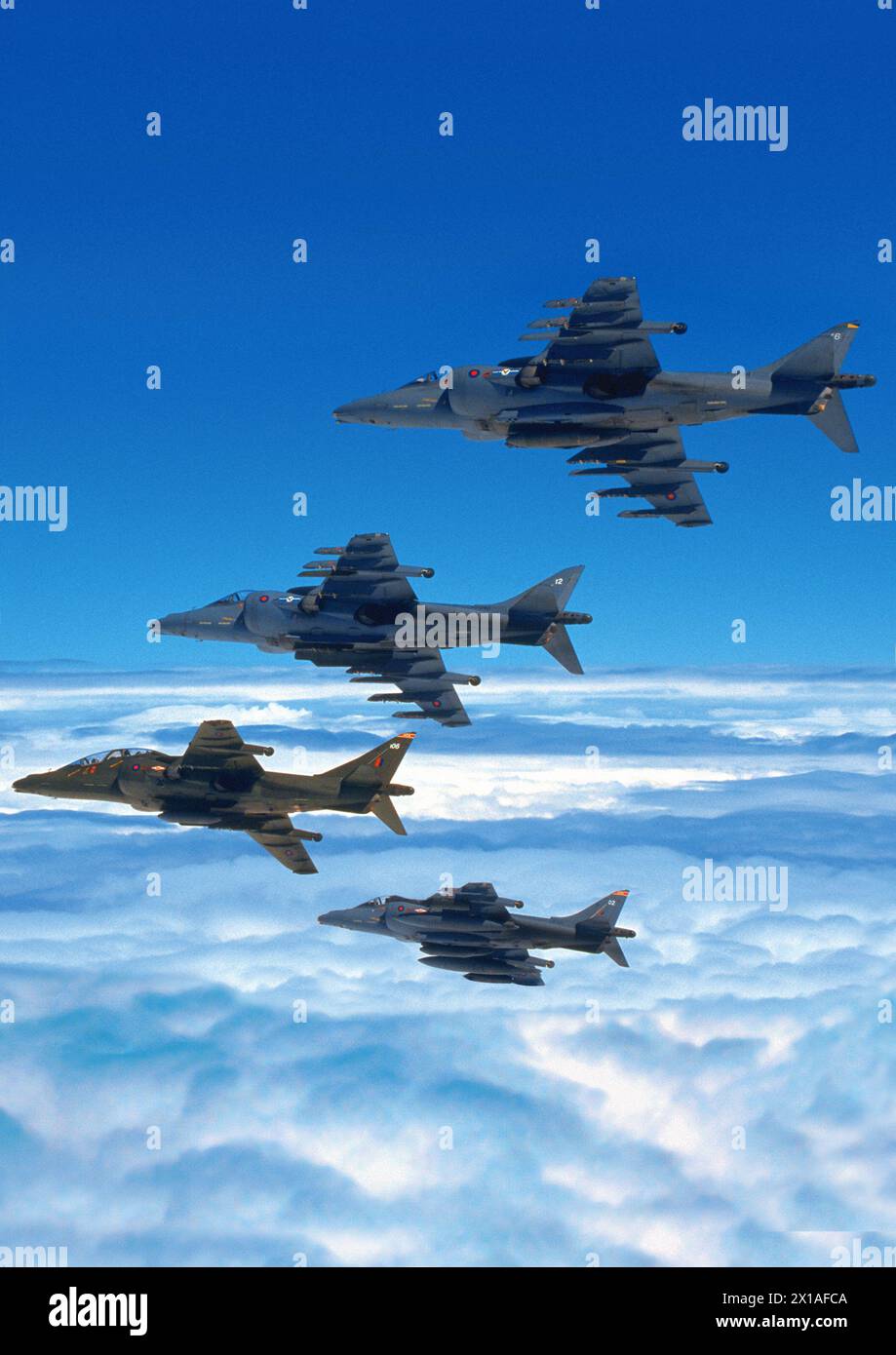 Eine Luft-Luft-Porträtaufnahme (A2A) von vier BAE-Harrier-Jets in Formation, die sich von der Kamera weg bewegen. Stockfoto