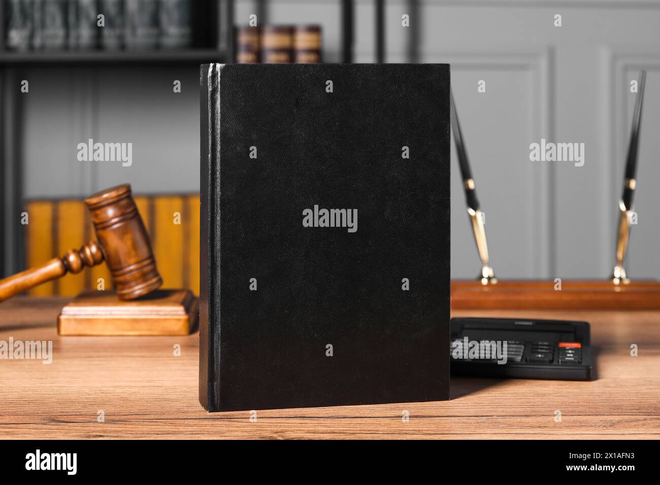 Steuerrecht. Buch, Taschenrechner und Hammer auf Holztisch Stockfoto