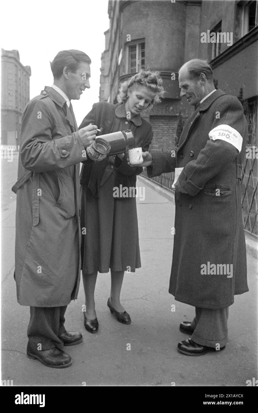 Wahltag in Wien, drei Wahlhelfer mit SPOe-Loop am Arm vor einem Wahllokal stehen, sich selbst Kaffee aus der Vakuumflasche trinken, 1949 - 19490101 PD1814 - Rechteinfo: Rights Managed (RM) Stockfoto