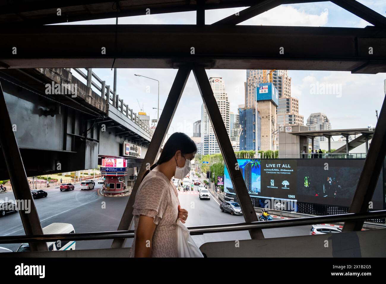 Fußgänger, die einen Spaziergang entlang des Skytrain-Bahnhofs Sala Daeng BTS in der Silom-Gegend von Bangkok, Thailand, Unternehmen. Die Straße darunter ist Rama IV Stockfoto