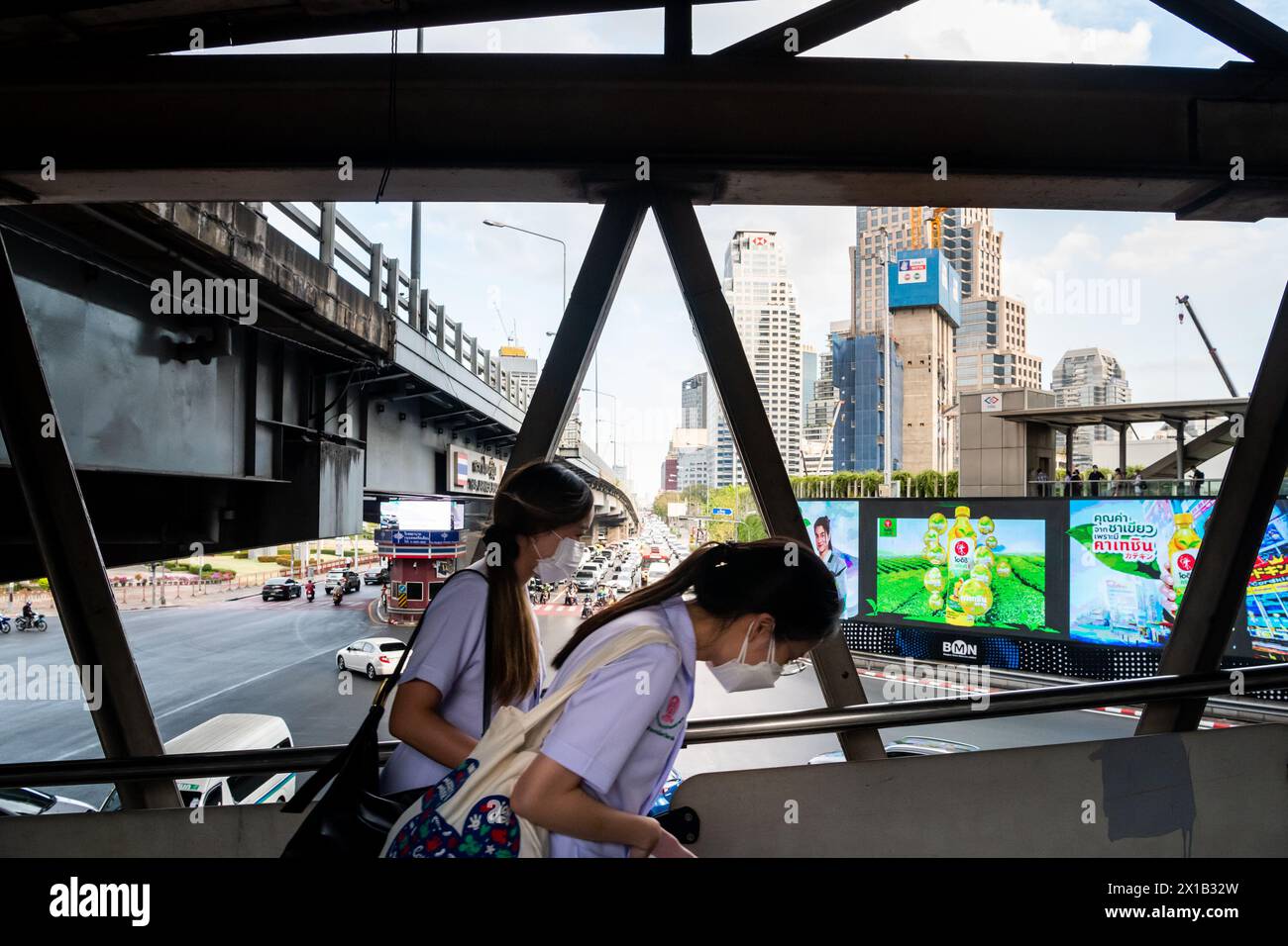 Fußgänger, die einen Spaziergang entlang des Skytrain-Bahnhofs Sala Daeng BTS in der Silom-Gegend von Bangkok, Thailand, Unternehmen. Die Straße darunter ist Rama IV Stockfoto