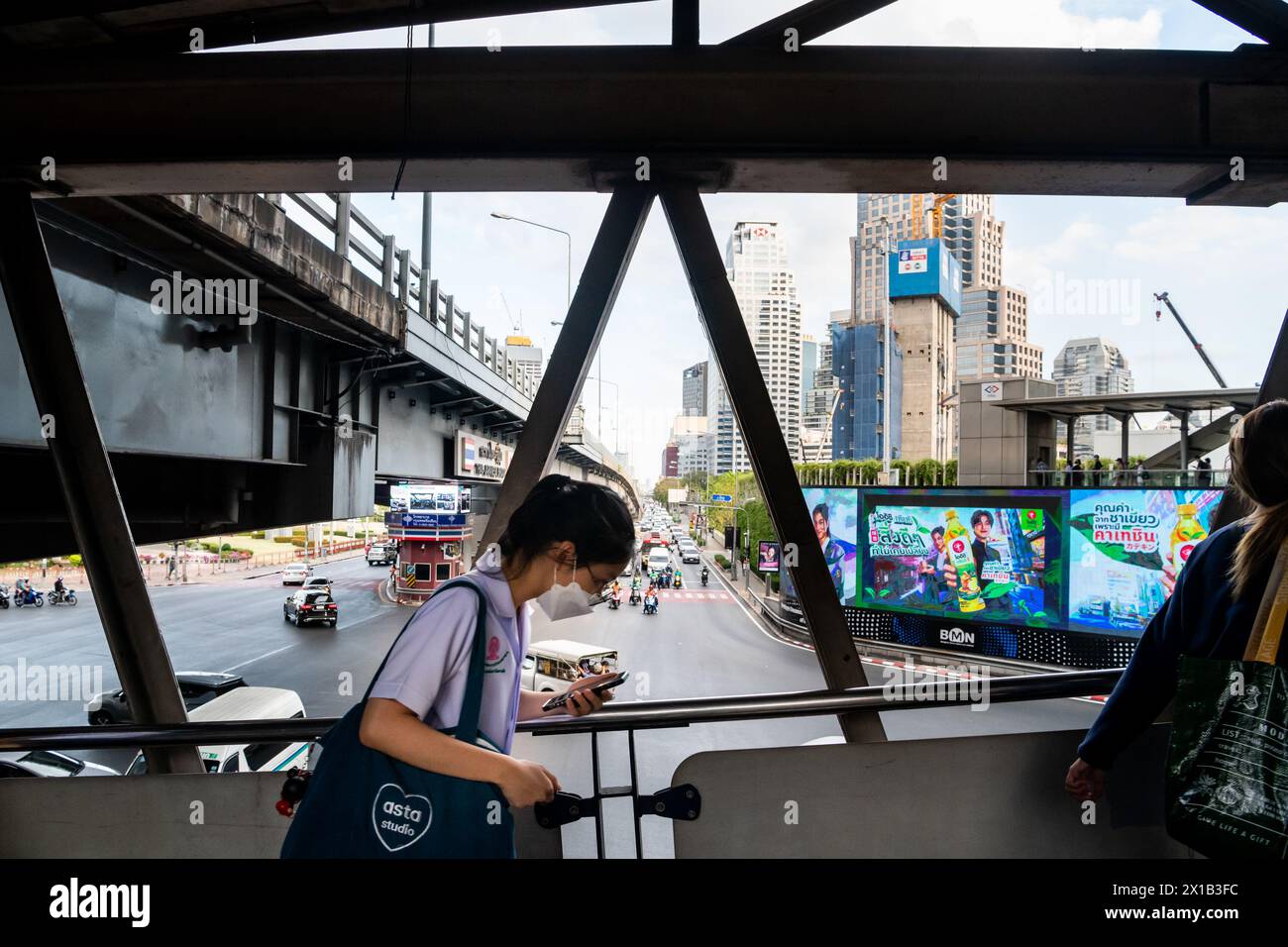 Fußgänger, die einen Spaziergang entlang des Skytrain-Bahnhofs Sala Daeng BTS in der Silom-Gegend von Bangkok, Thailand, Unternehmen. Die Straße darunter ist Rama IV Stockfoto