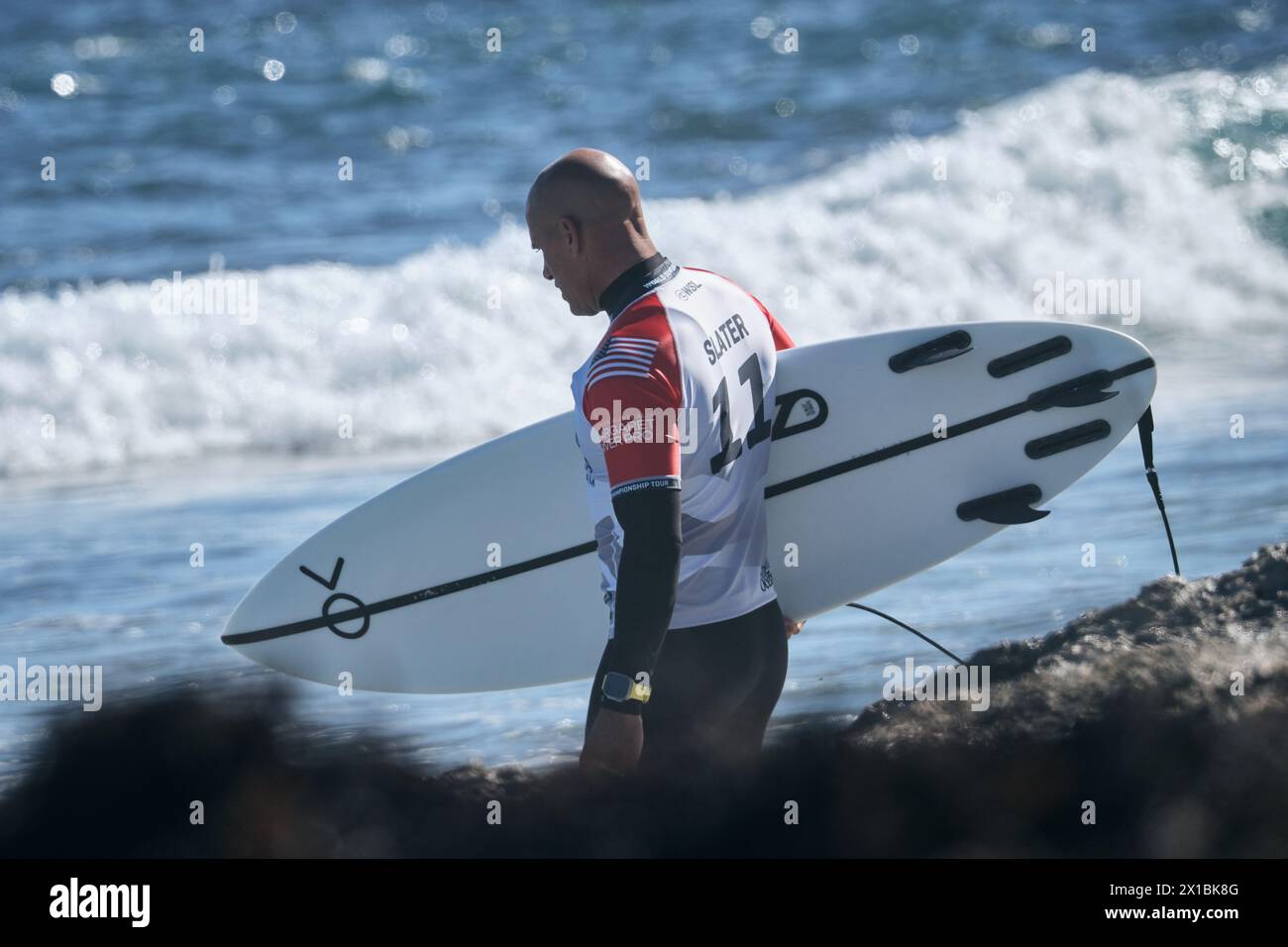 Der amerikanische Profi-Surfer Kelly Slater trägt sein Surfbrett, das im Margaret River Pro 2024 in Western Australia ins Wasser eindringen will. Stockfoto