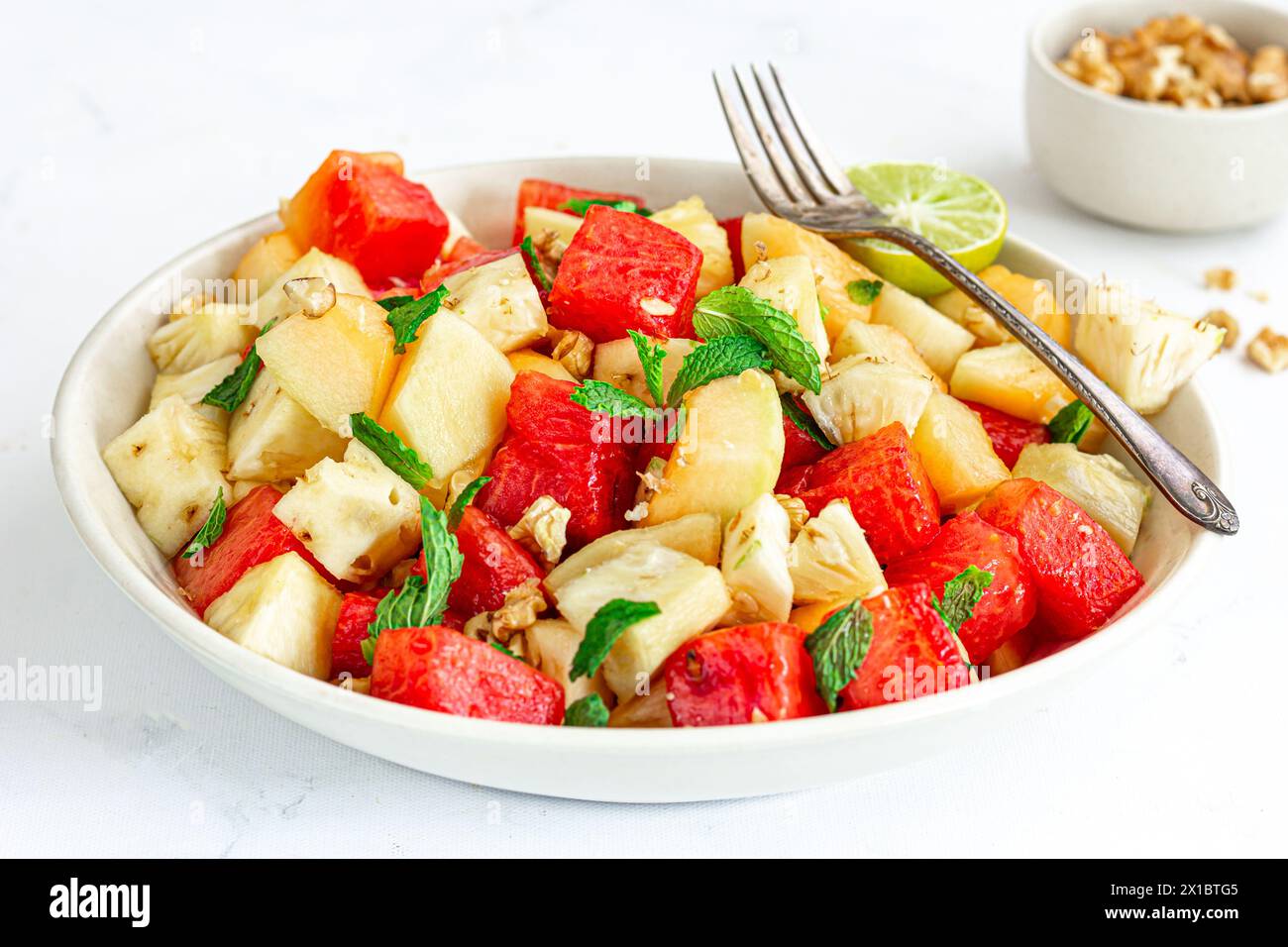 Erfrischend und gesund Wassermelone und Ananassalat garniert mit Minzblättern Nahaufnahme gesunde Lebensmittel Fotografie Stockfoto