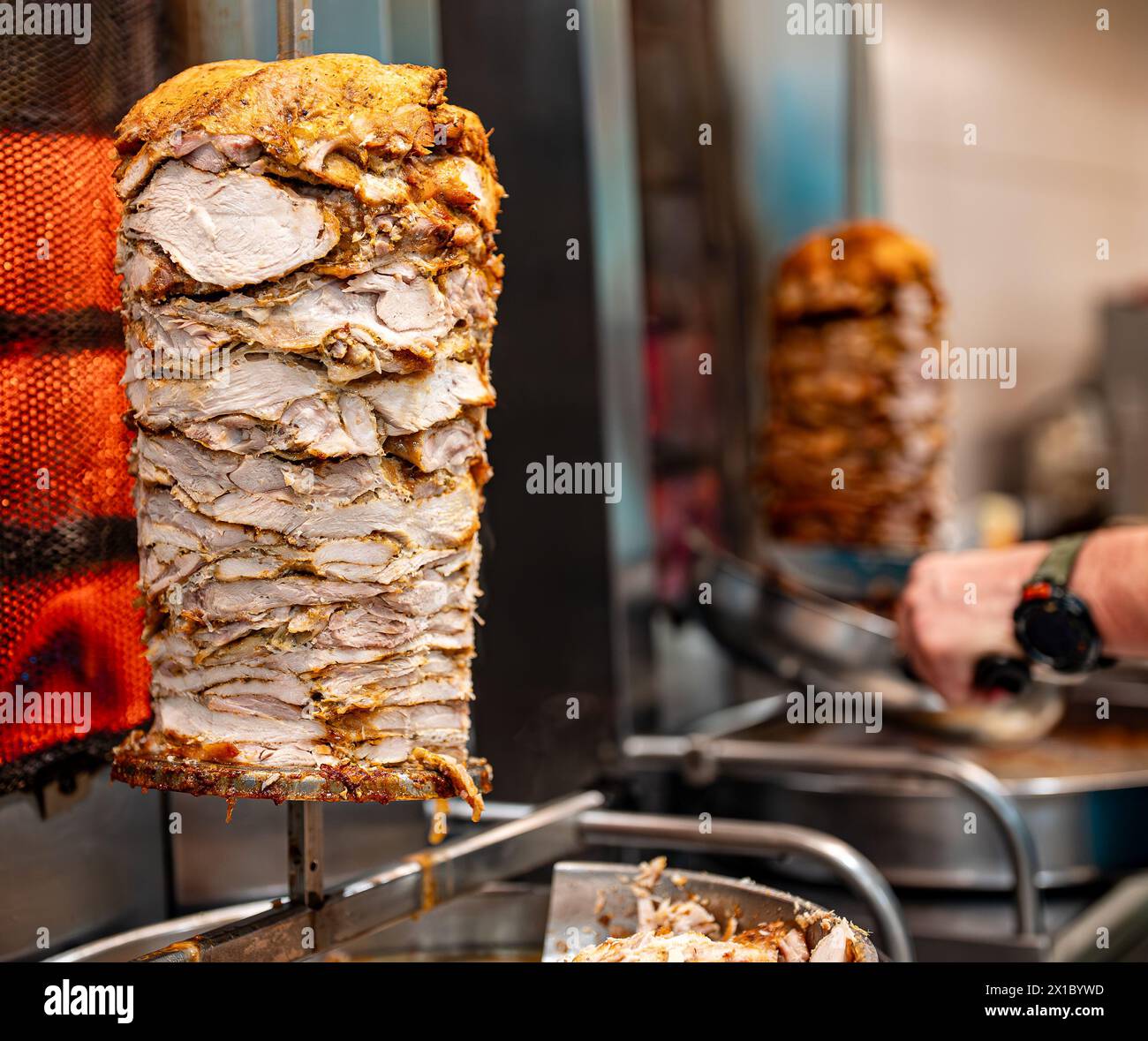 Saftiges Fleisch wird auf einem Shawarma-Spieß gebraten. Stockfoto