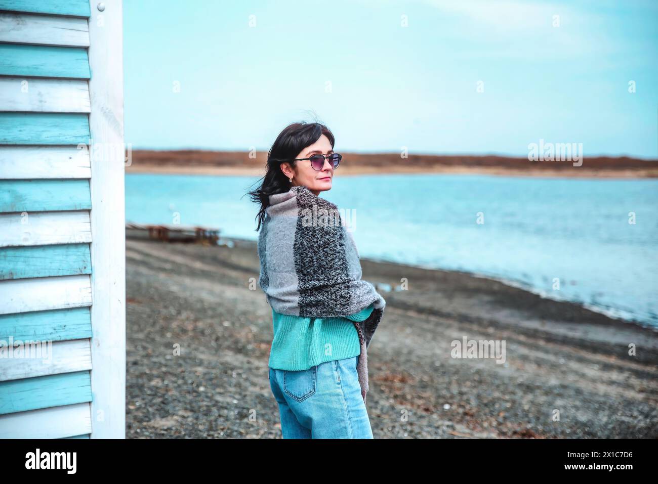 49-jährige Russin in blauem Pullover an einem frühen Frühlingstag gegen das japanische Meer Stockfoto