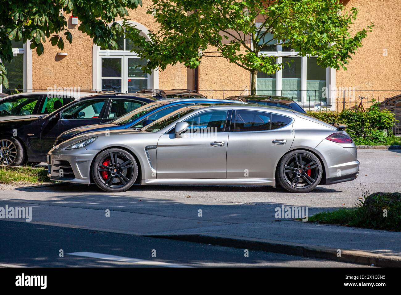 Silberner Porsche Panamera parkte auf der Stadtstraße, sonniger Tag. Stockfoto