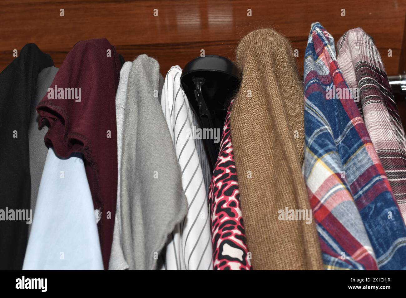Die Art von Kleidung hängt fest an Kleiderbügeln im Schrank. Stockfoto