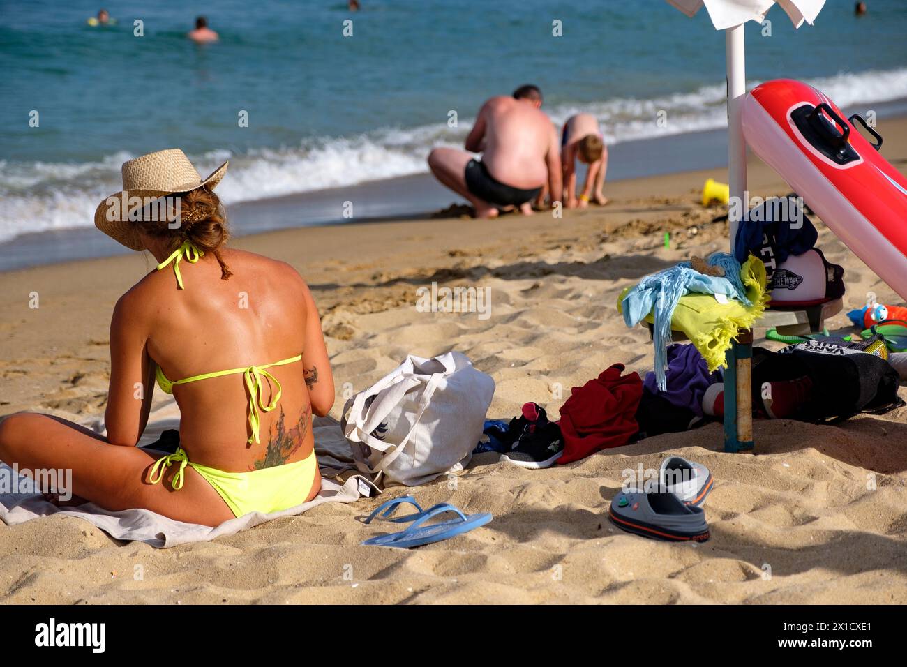 Leute, die Spaß am goldenen Sandstrand am Schwarzen Meer haben. Sie genießen ihren Urlaub an einem sonnigen Tag. Stockfoto