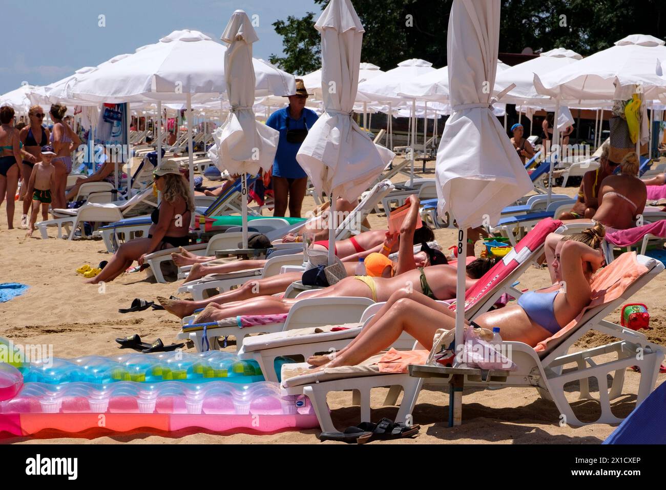 Touristen im Urlaub haben Spaß am Sonnenbaden am Strand und genießen die Sommerzeit. Golden Sands Beach ist ein Touristenziel in Varna am Schwarzen Meer. Stockfoto