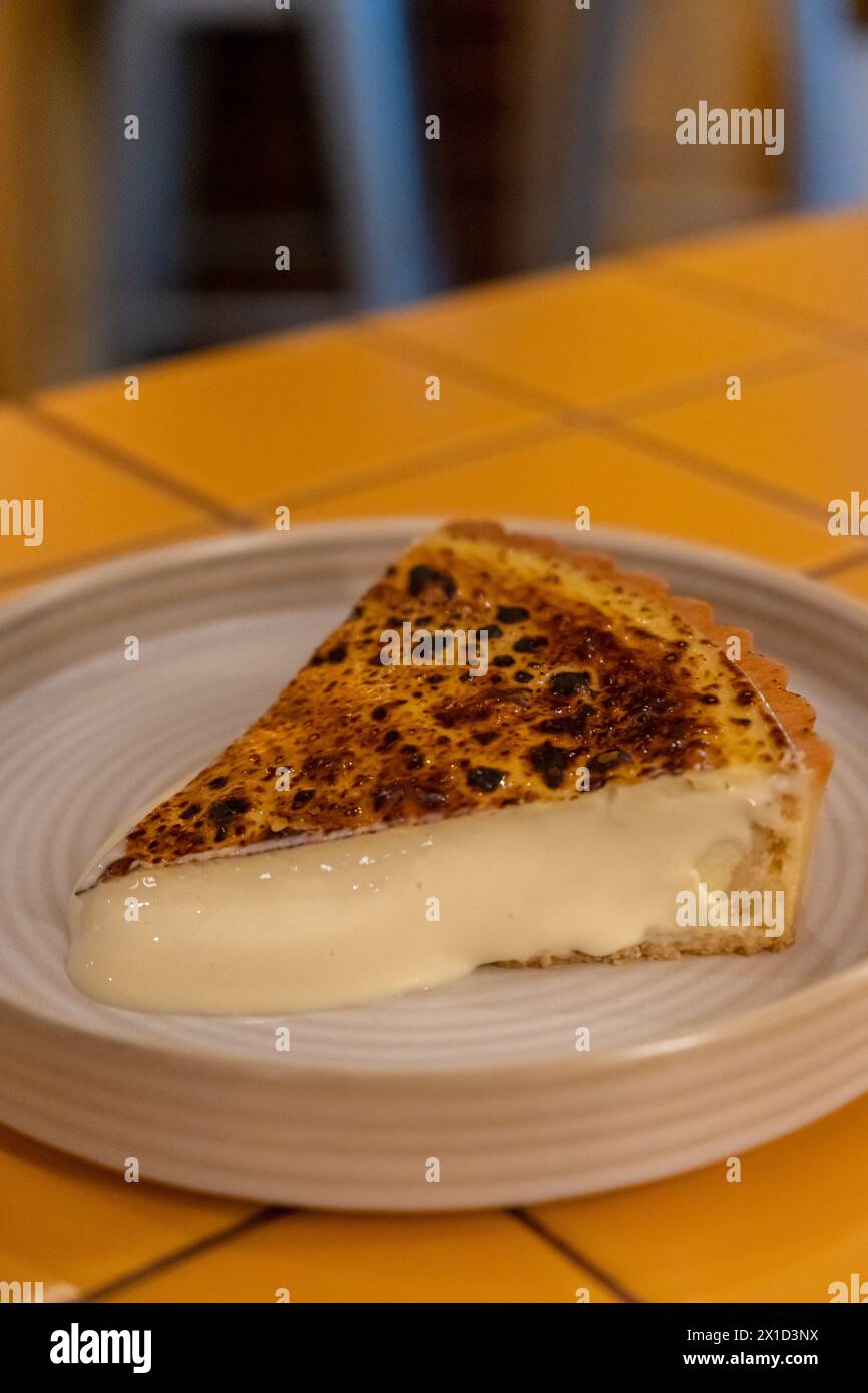 Gebrannter Käsekuchen, enthält Frischkäse und Blauschimmelkäse mit Mandelsabel auf Teller Stockfoto