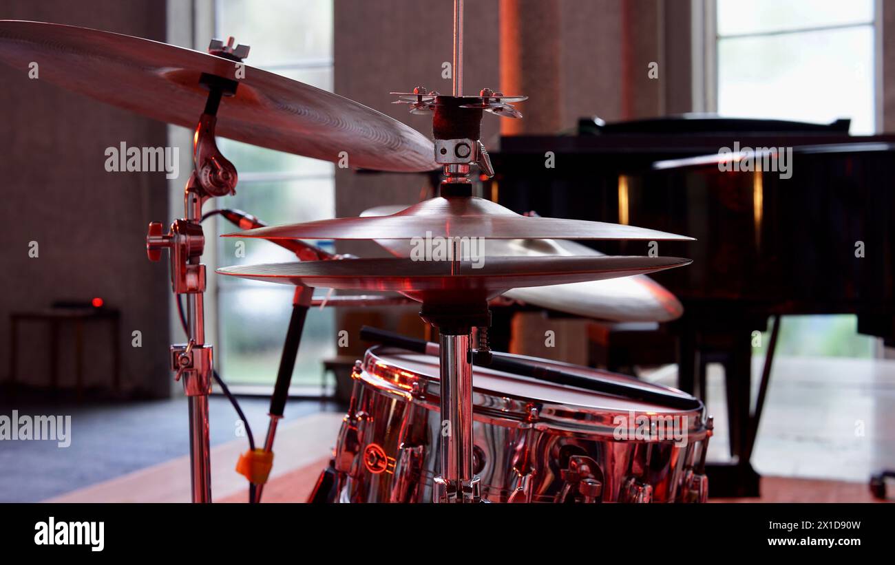 Detail eines Schlagzeuges auf der Bühne. Ein Flügel im Hintergrund. Stockfoto