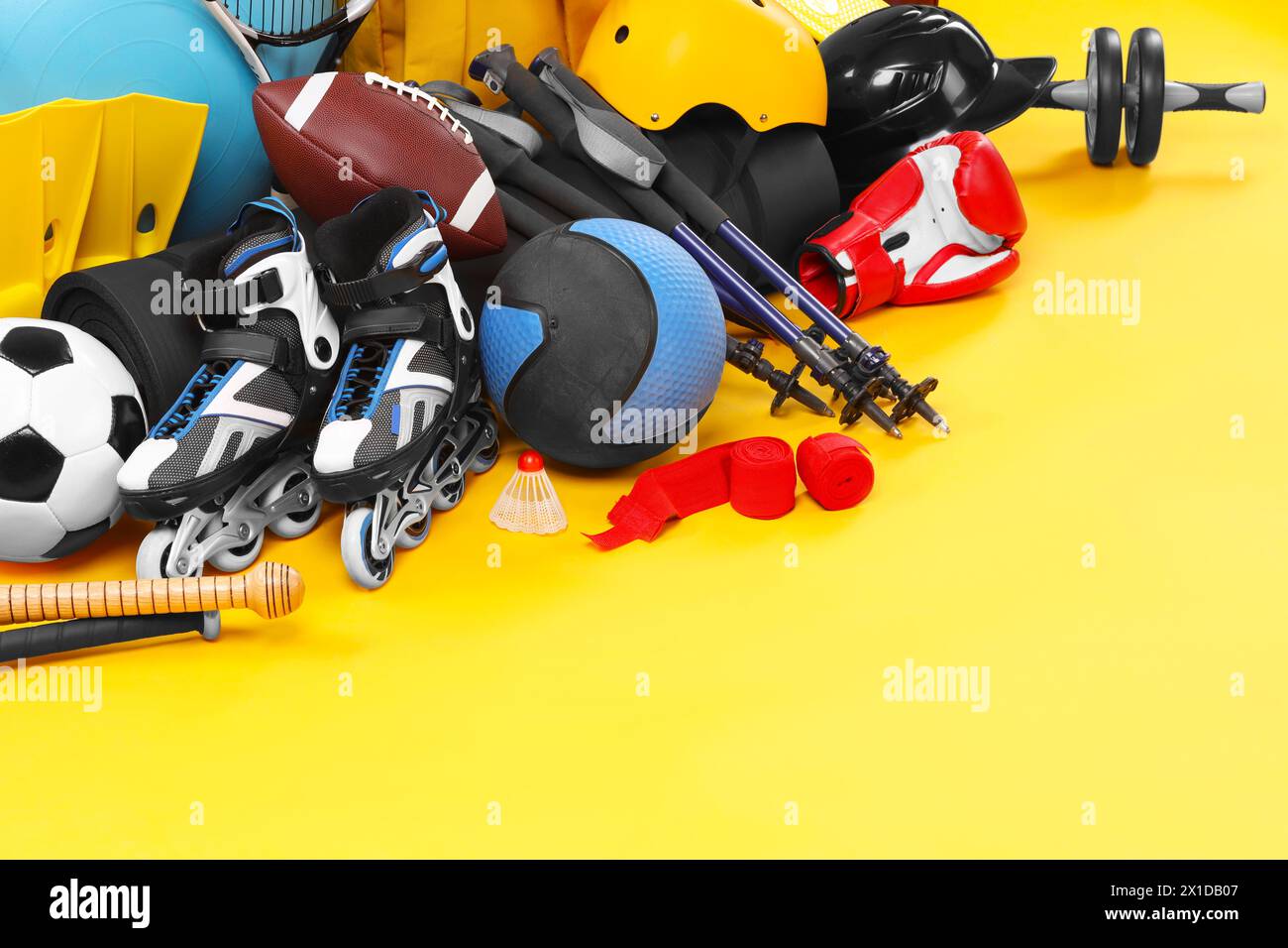 Viele verschiedene Sportgeräte auf gelbem Hintergrund, Platz für Text Stockfoto