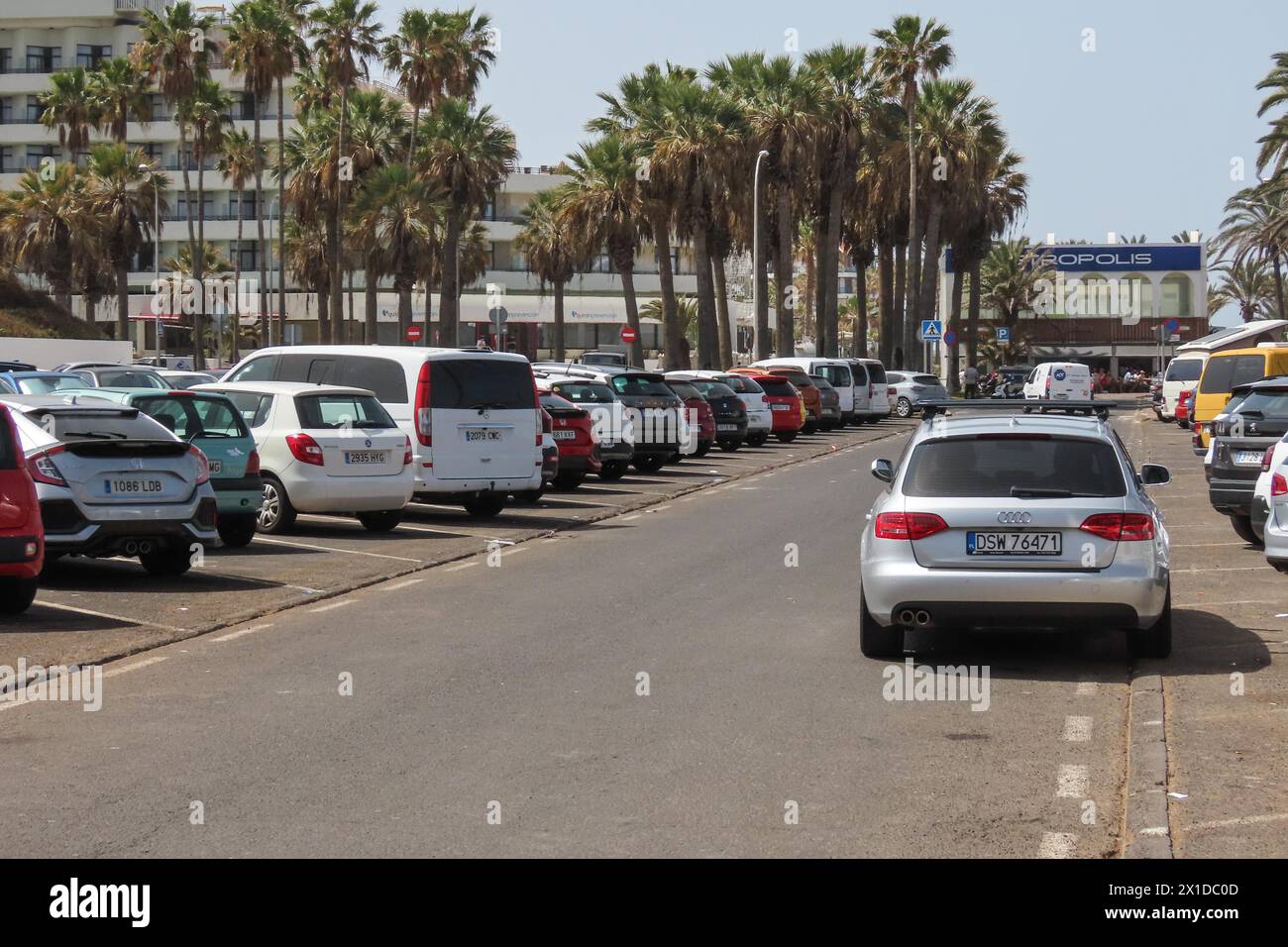 Los Cristianos, Teneriffa, 16. April 2024 - Parken ist ein großes Problem an beliebten Orten auf Teneriffa. Hier, Los Cristianos, ist nach 9:00 Uhr kaum Platz verfügbar. - Touristen laufen an Anti-Touristen-Plakaten entlang des Strandes in Los Cristianos vorbei. Auf dem Poster steht, dass die Kanarischen Inseln eine Grenze haben. Die gelben Schilder werben für den anti-touristischen Protest am Samstag, den 20. April. In Santa Cruz de Teneriffa. Parken ist auch ein großes Problem in der Gegend, da unzählige Besucher Tausende von Plätzen füllen, was für die Bewohner und Besucher gleichermaßen Kopfschmerzen bereitet. Quelle: Stop Press Media/Alamy Live News Stockfoto