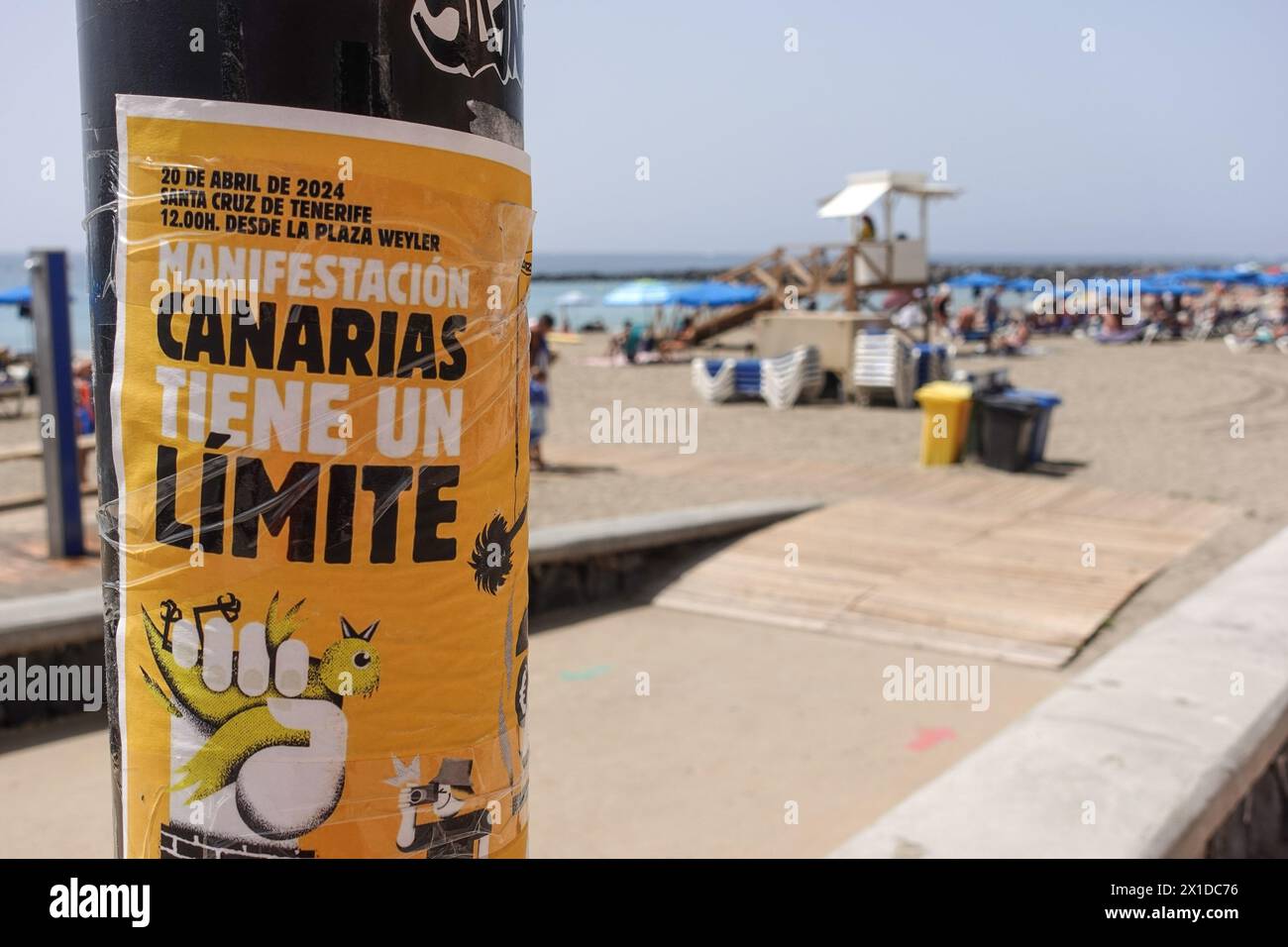 Los Cristianos, Teneriffa, 16. April 2024 - Touristen laufen an Anti-Touristen-Plakaten entlang der Strandfront in Los Cristianos vorbei. Auf dem Poster steht, dass die Kanarischen Inseln eine Grenze haben. Die gelben Schilder werben für den anti-touristischen Protest am Samstag, den 20. April. In Santa Cruz de Teneriffa. Parken ist auch ein großes Problem in der Gegend, da unzählige Besucher Tausende von Plätzen füllen, was für die Bewohner und Besucher gleichermaßen Kopfschmerzen bereitet. Quelle: Stop Press Media/Alamy Live News Stockfoto