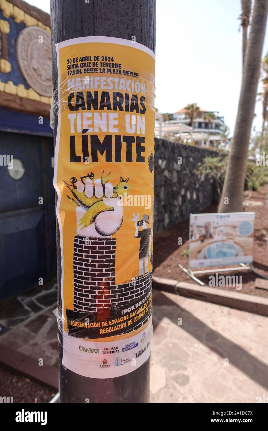 Los Cristianos, Teneriffa, 16. April 2024 - Touristen laufen an Anti-Touristen-Plakaten entlang der Strandfront in Los Cristianos vorbei. Auf dem Poster steht, dass die Kanarischen Inseln eine Grenze haben. Die gelben Schilder werben für den anti-touristischen Protest am Samstag, den 20. April. In Santa Cruz de Teneriffa. Parken ist auch ein großes Problem in der Gegend, da unzählige Besucher Tausende von Plätzen füllen, was für die Bewohner und Besucher gleichermaßen Kopfschmerzen bereitet. Quelle: Stop Press Media/Alamy Live News Stockfoto