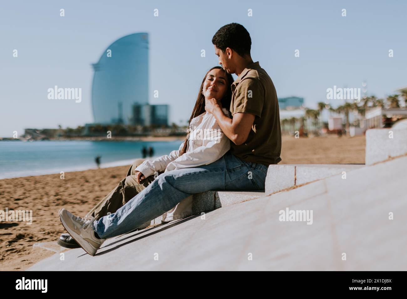 Entspannen Sie sich an den Sandstränden von Barcelonas mit dem berühmten Hotel im Hintergrund Stockfoto