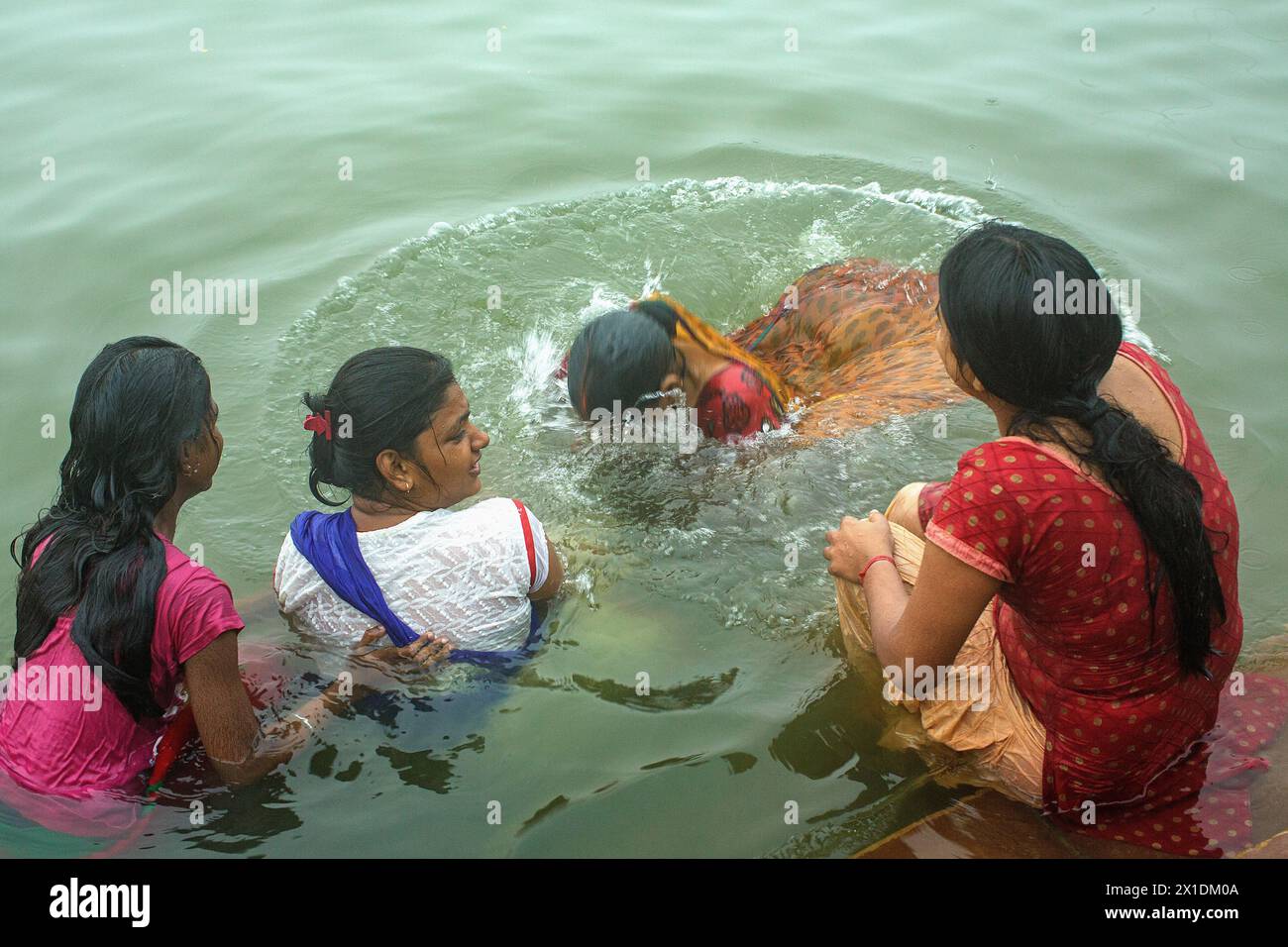 Pilgerinnen tauchen in den Ganges-Fluss bei Varanasi, Indien. Stockfoto
