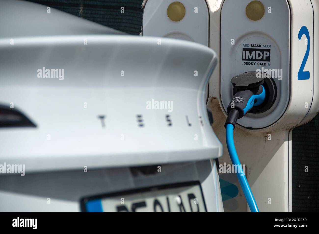 Tesla Fahrzeug lädt seine Batterien an einer Ladestation oder an einer elektrischen Station an einem sonnigen Tag in Lissabon auf Stockfoto