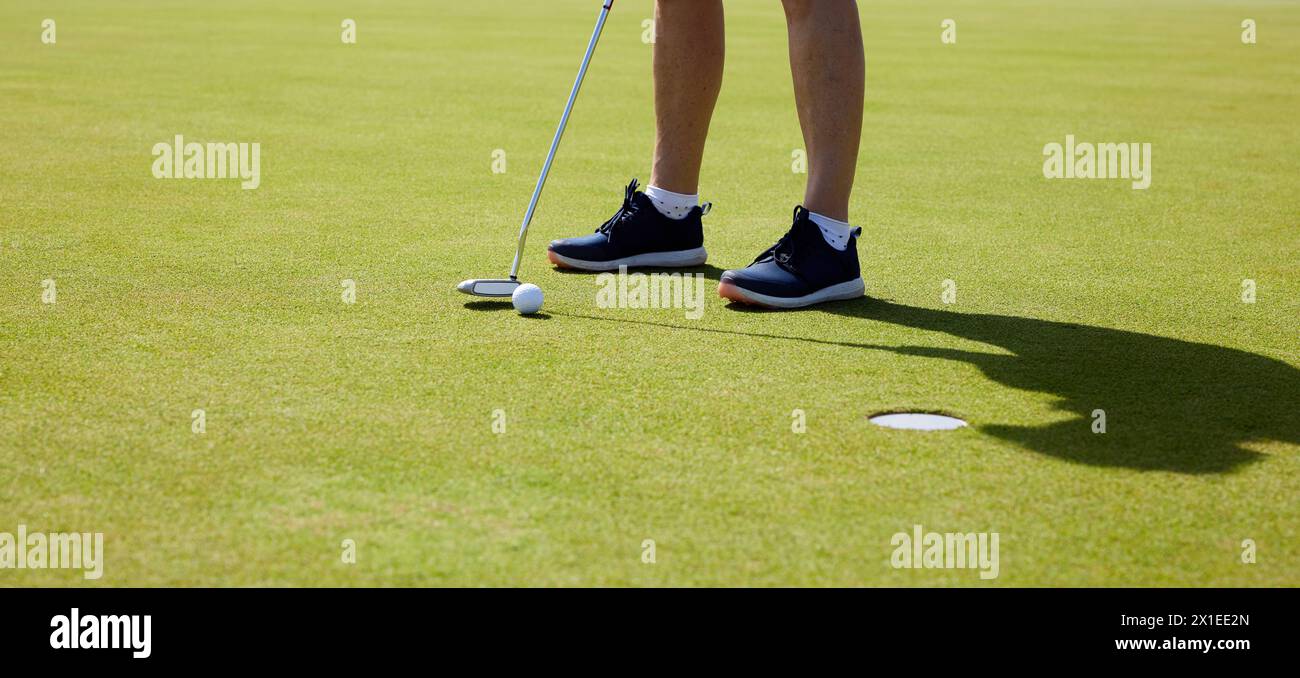 Der Golfer übt auf dem Putting Green, am ersten Morgen. Stockfoto