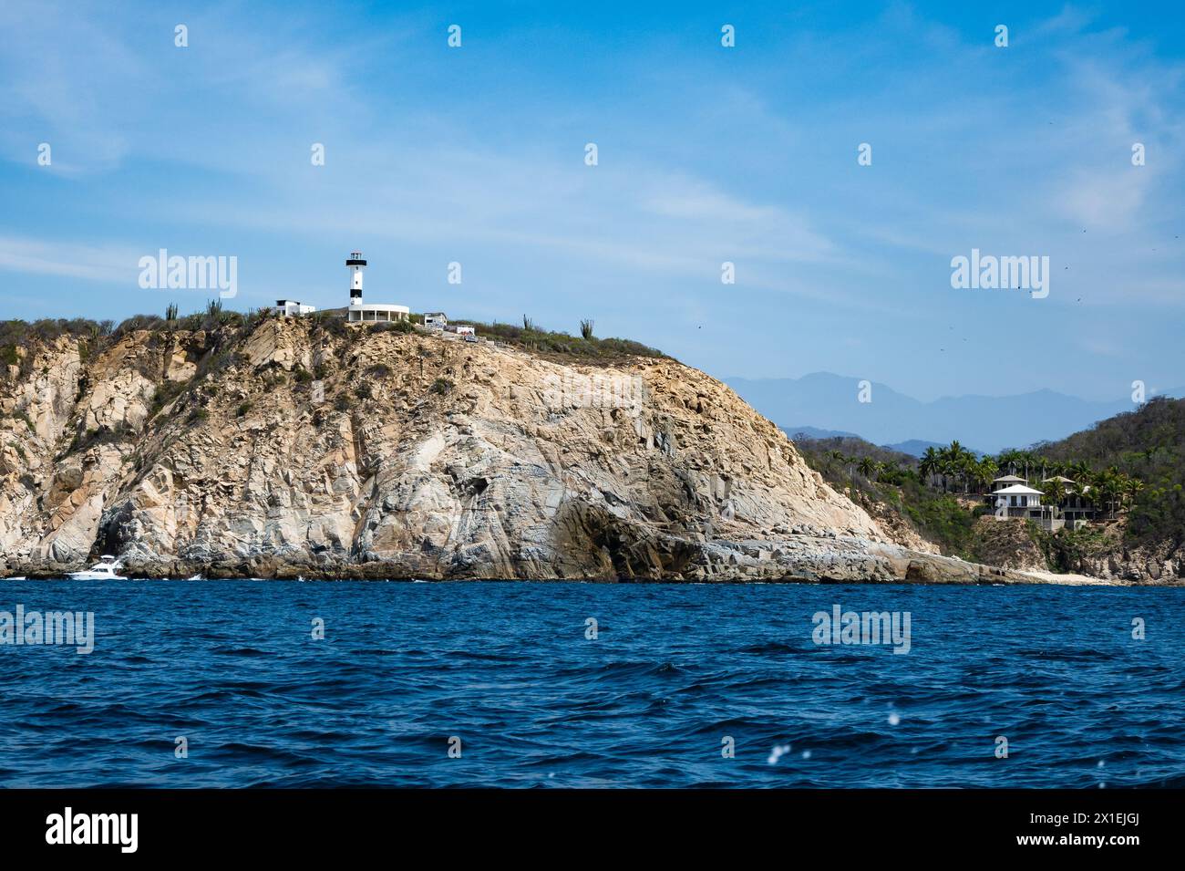 Leuchtturm auf der felsigen Klippe an der Pazifikküste von Huatulco. Oaxaca, Mexiko. Stockfoto