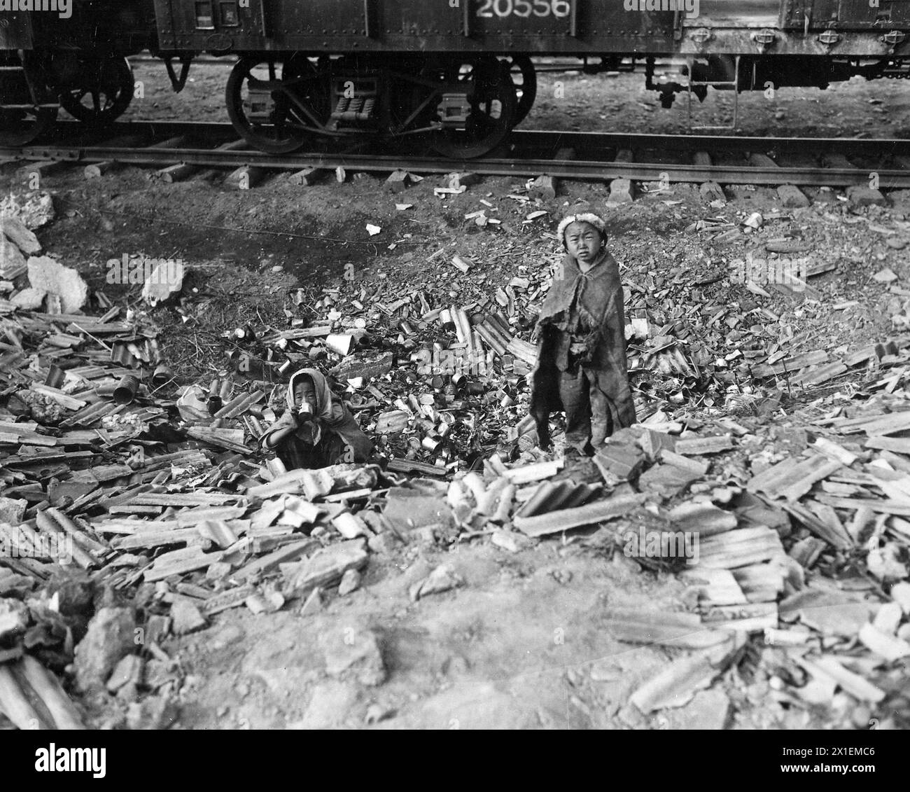 Obdachlos suchen Bruder und Schwester leere Dosen nach Lebensmitteln und versuchen, sich neben einem kleinen Feuer in Seoul, Korea, den Bahnhöfen CA warm zu halten. November 1950 Stockfoto