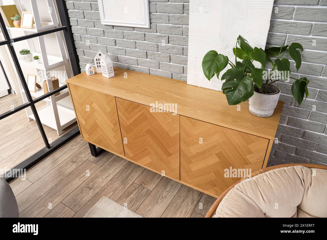 Sideboard aus Holz mit Zimmerpflanzen und Einrichtung im modernen Wohnzimmer Stockfoto