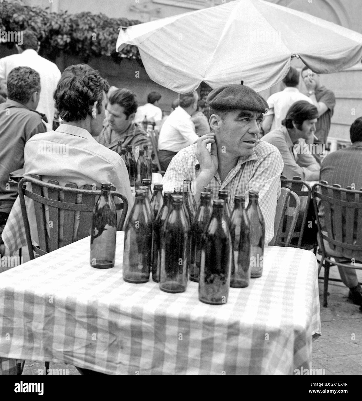 Die Sozialistische Republik Rumänien, ca. 1979. Männer trinken auf der Außenterrasse einer Bar. Mann mit einer großen Anzahl leerer Bierflaschen vor ihm auf dem Tisch. Stockfoto