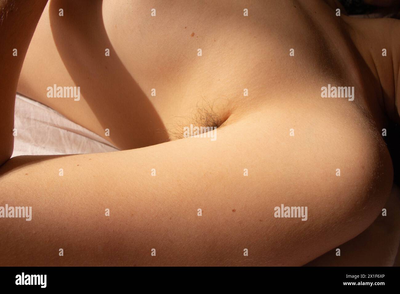 Stellen Sie die Schönheitsstandards heraus und feiern Sie die natürliche Authentizität mit diesem eindrucksvollen Bild einer weiblichen Achselhöhle, die mit Haaren verziert ist Stockfoto