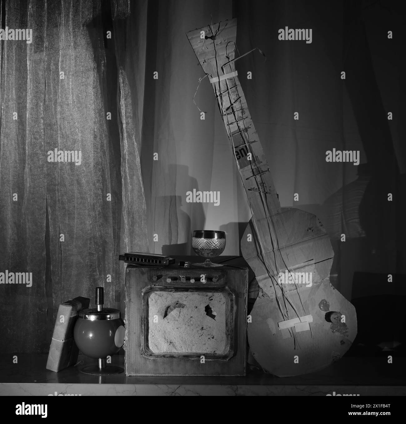 Grungy-Pappmodelle einer elektrischen Blues-Gitarre, einem rauen Verstärker und einer Mundharmonika. Musik, Performance, Blues- und Rock-Stil, Instrumente im Inneren Stockfoto