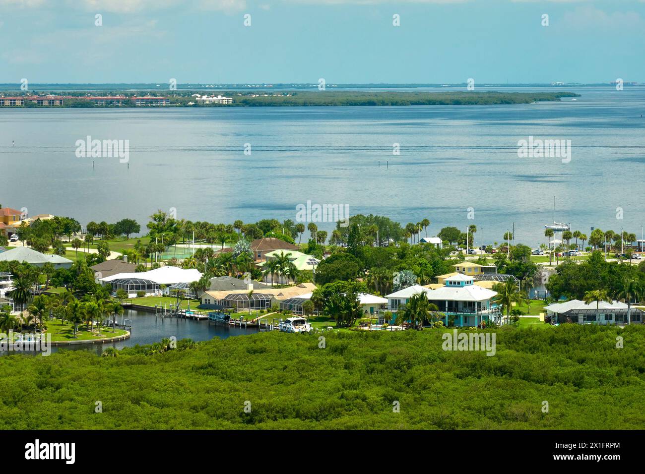 Luftaufnahme von ländlichen Privathäusern in abgelegenen Vororten in der Nähe von Florida Wildlife Feuchtgebiete mit grüner Vegetation an der Küste der Meeresbucht. Wohnen in der Nähe Stockfoto