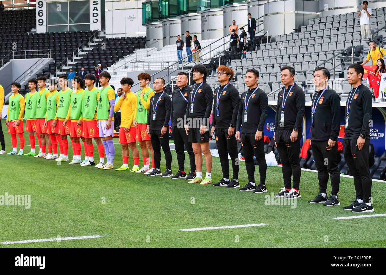 Doha, Katar. April 2024. Substitute und Trainer aus China treten für Nationalhymnen an, bevor sie am 16. April 2024 im Jassim bin Hamad Stadium in Doha, Katar, das Spiel der Gruppe B zwischen China und Japan des AFC U23 Asian Cup Qatar 2024 ausgetragen haben. Quelle: Nikku/Xinhua/Alamy Live News Stockfoto