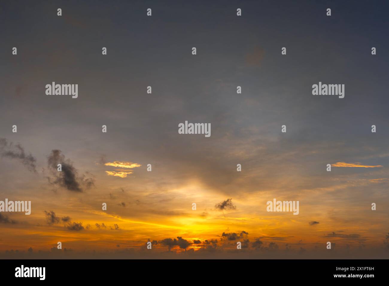 Wunderschöne Sonnenuntergangslandschaft. Leuchtend bunte orange und gelbe Wolken am Horizont Stockfoto