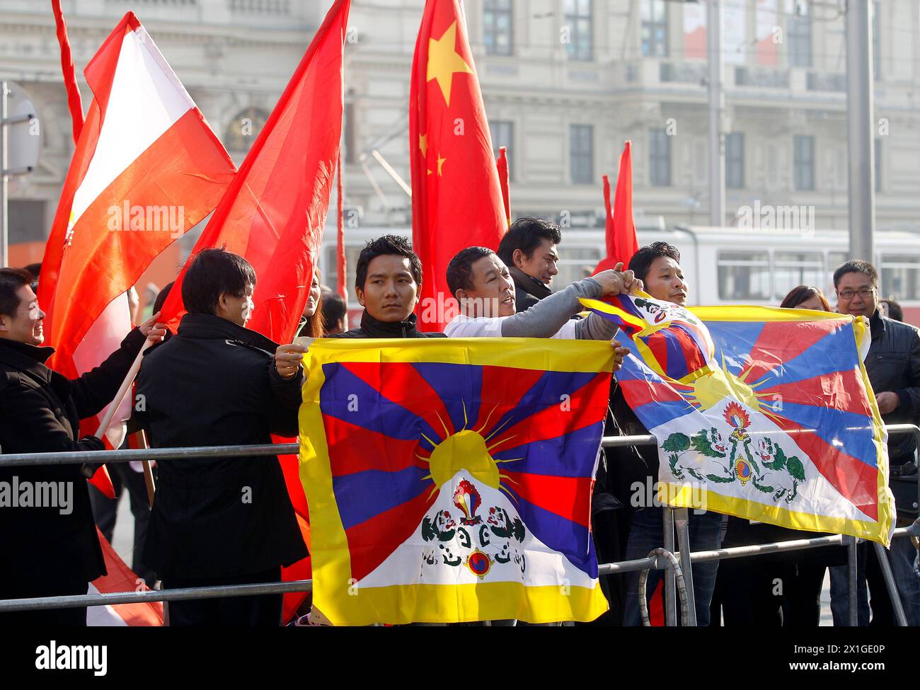 Während Tibeter im Exil am 31. Oktober 2011 vor dem Hotel Imperial in Wien gegen den Präsidenten der Volksrepublik China Hu Jintao demonstrieren, begrüßen chinesische Personen den Präsidenten mit österreichischen und chinesischen Fahnen. - 20111031 PD0401 - Rechteinfo: Rights Managed (RM) Stockfoto