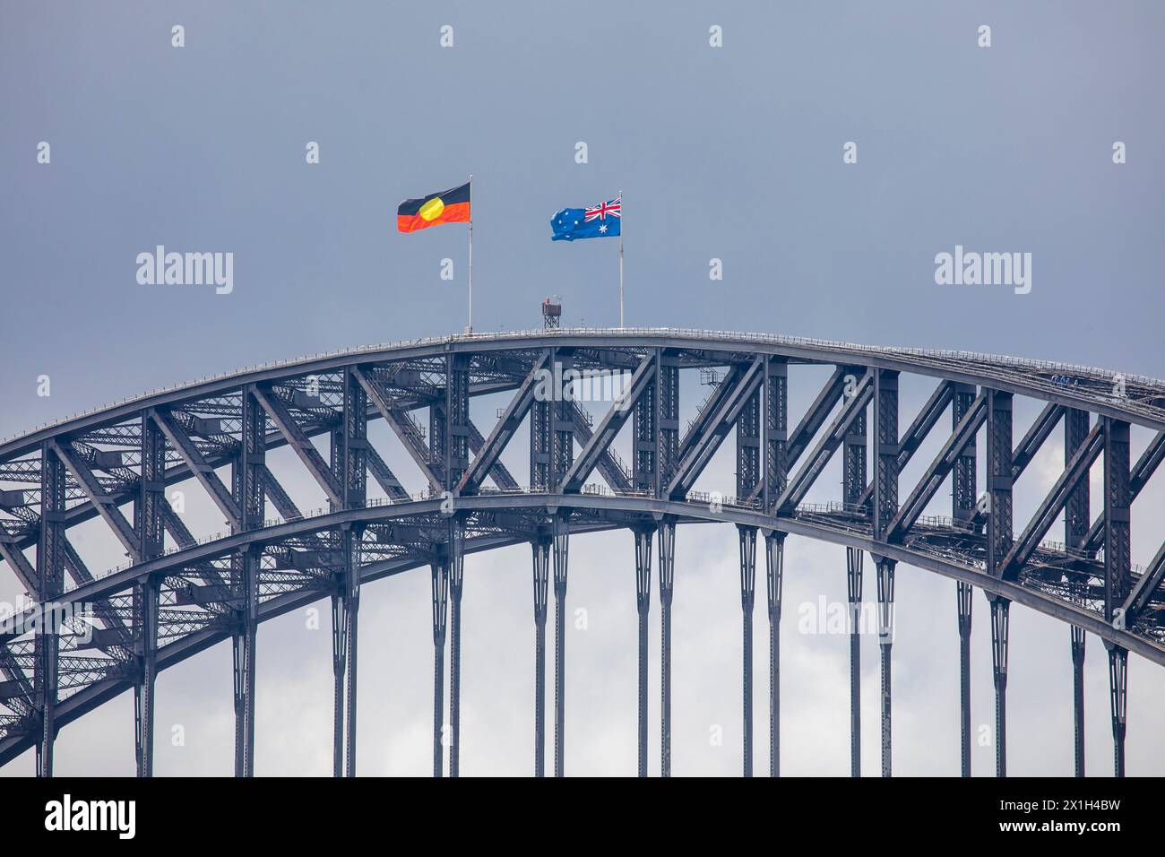 Die 1932 eröffnete Sydney Harbour Bridge führt die australische Nationalflagge und die indigene Flagge Stockfoto