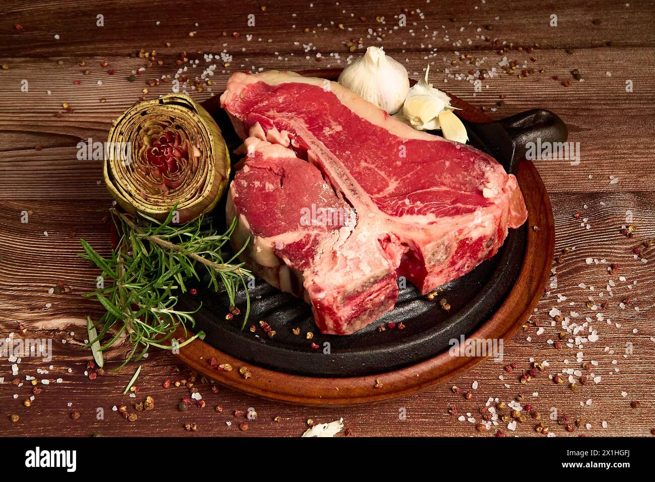 Fleischvorschnitt auf einem Holztisch vor dunklem schwarzem Hintergrund Stockfoto