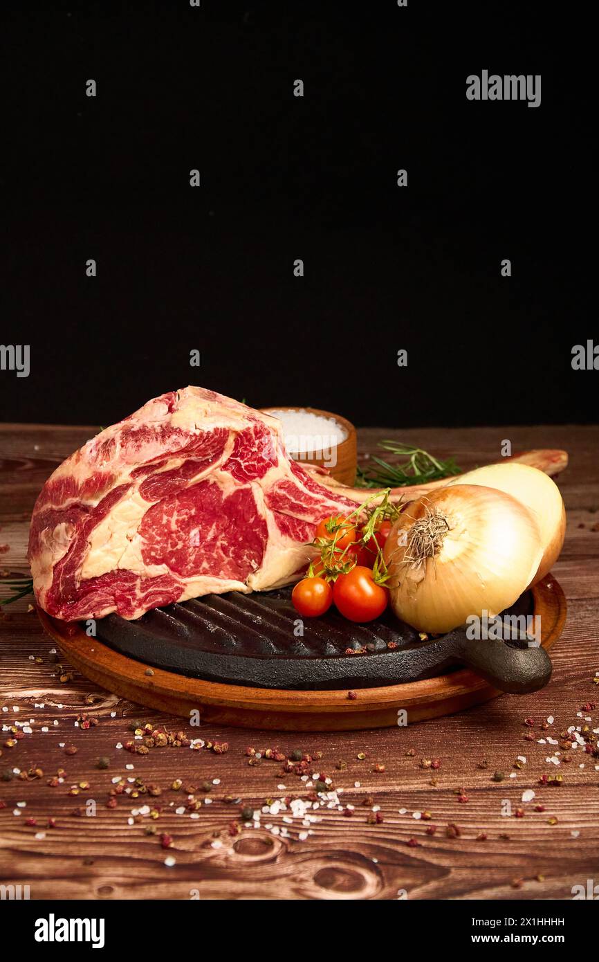 Fleischvorschnitt auf einem Holztisch vor dunklem schwarzem Hintergrund Stockfoto