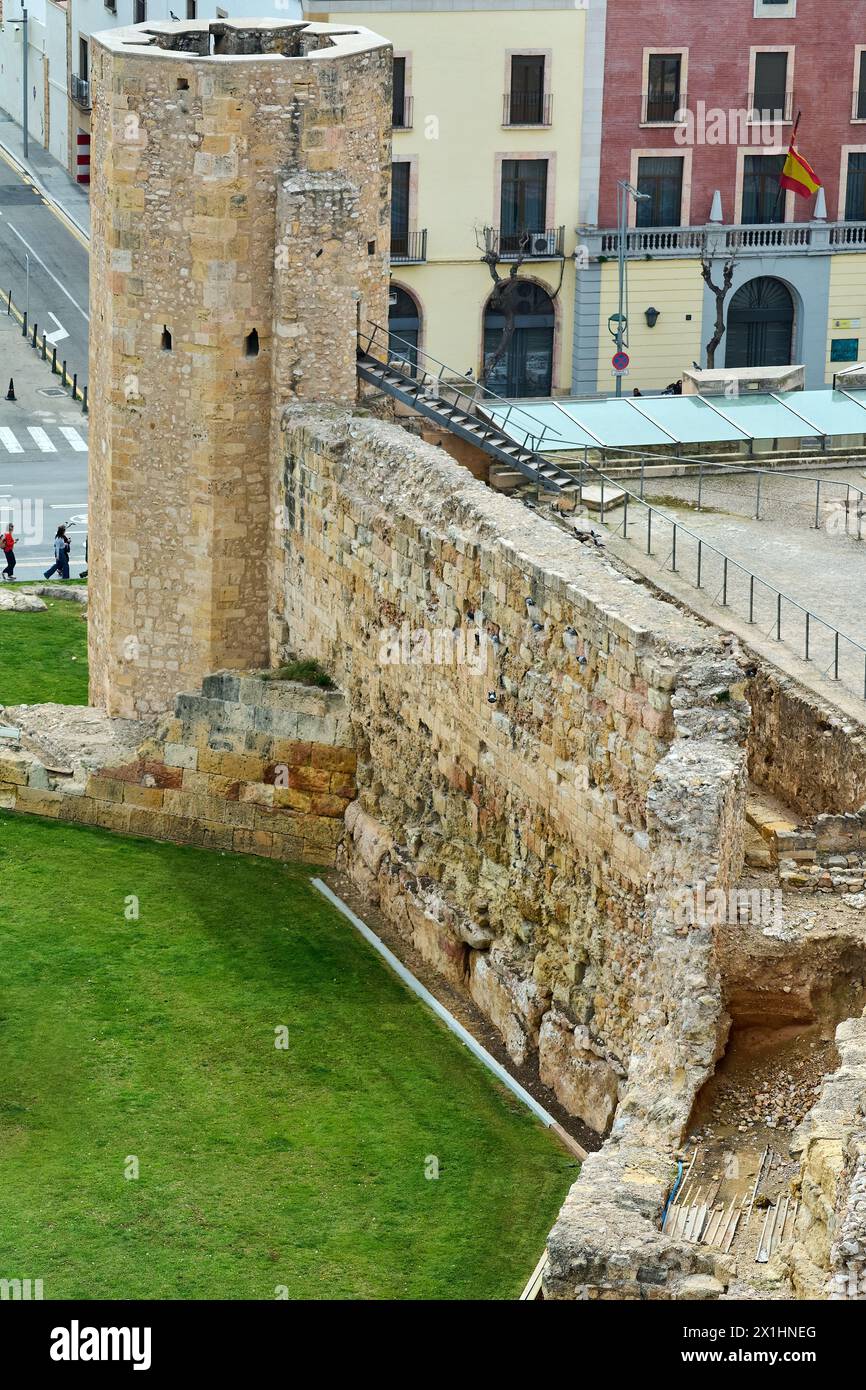 Tarragona, Spanien - 17. April 2024: Bild einer alten Steinmauer und eines Turms in Tarragona, die historische Architektur mit modernen Gebäuden und zeigt Stockfoto