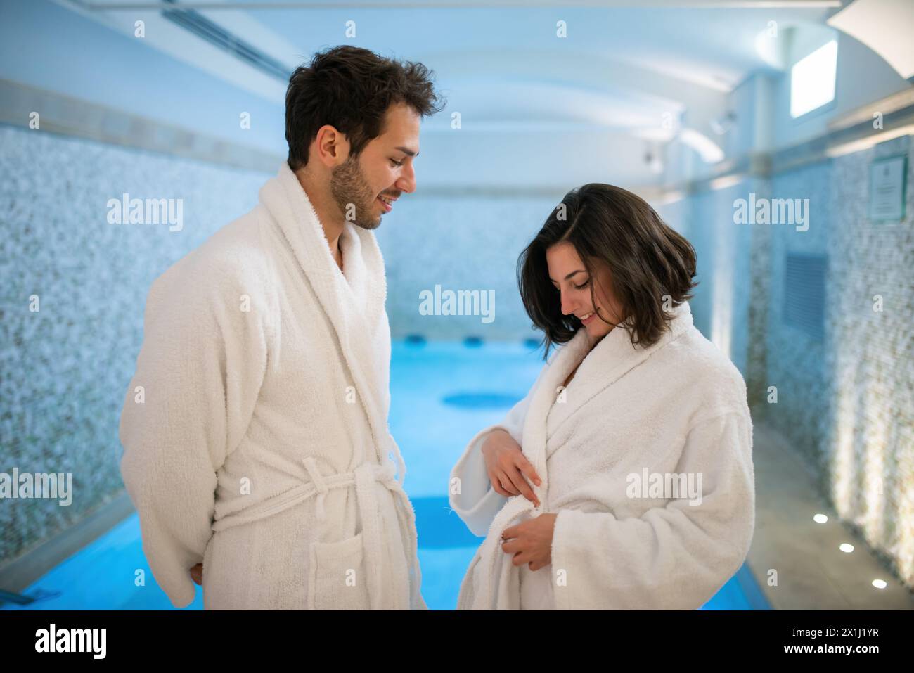 Junges Paar, das sich in einem Hallenbad amüsiert Stockfoto