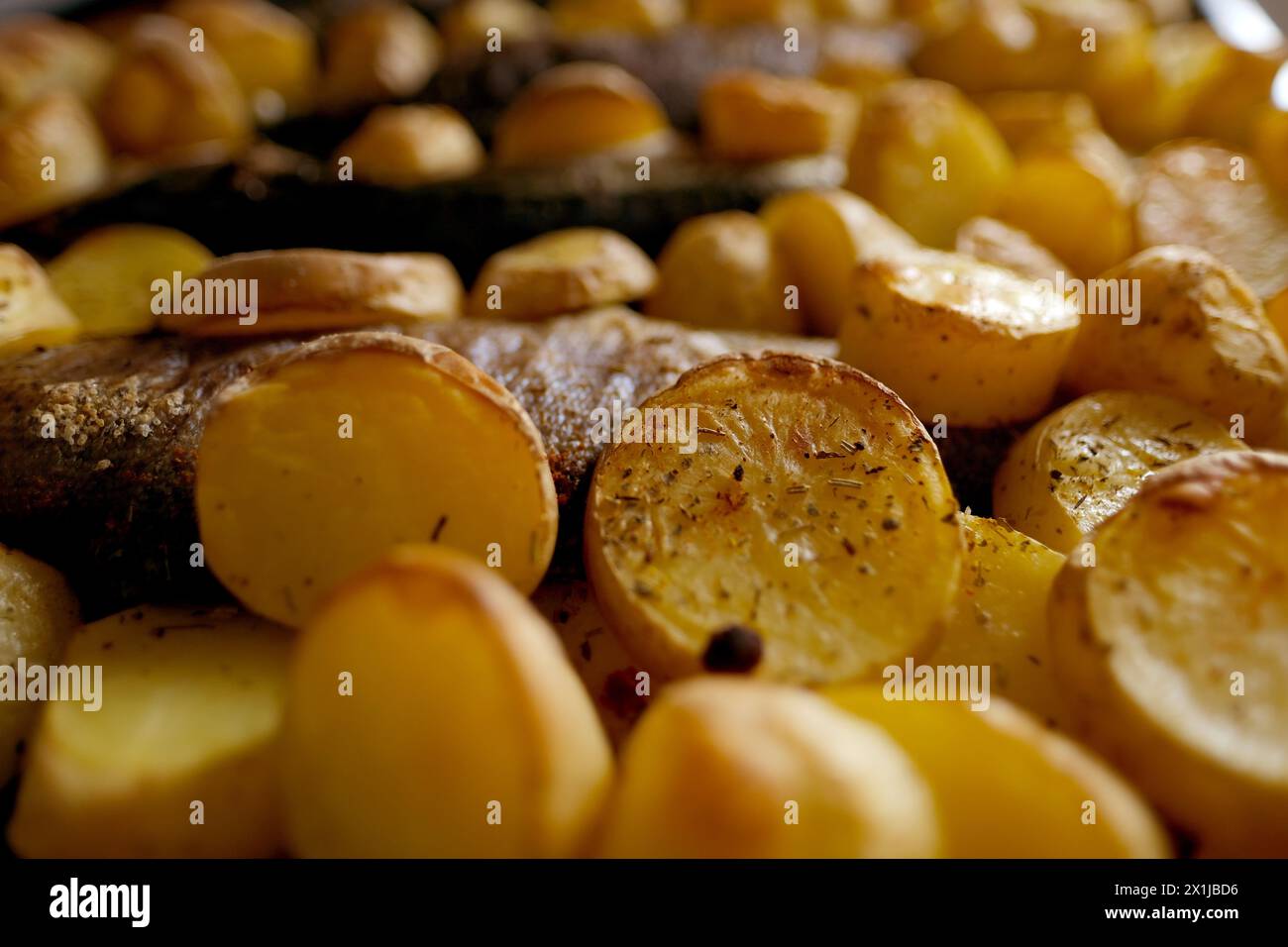 Im Ofen gebackene Kartoffeln mit aromatischen Gewürzen, gegrillter Seebrassen-Fisch mit köstlicher Currysauce, Junkfood-Konzept, traditionelle Familienparty, Fischgerichte, Stockfoto