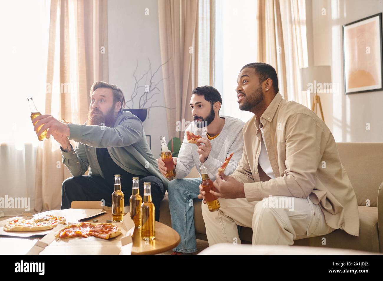 Drei gutaussehende, interrassische Männer in lässiger Kleidung, die eine tolle Zeit zusammen haben, an einem Tisch sitzen und Bier genießen. Stockfoto