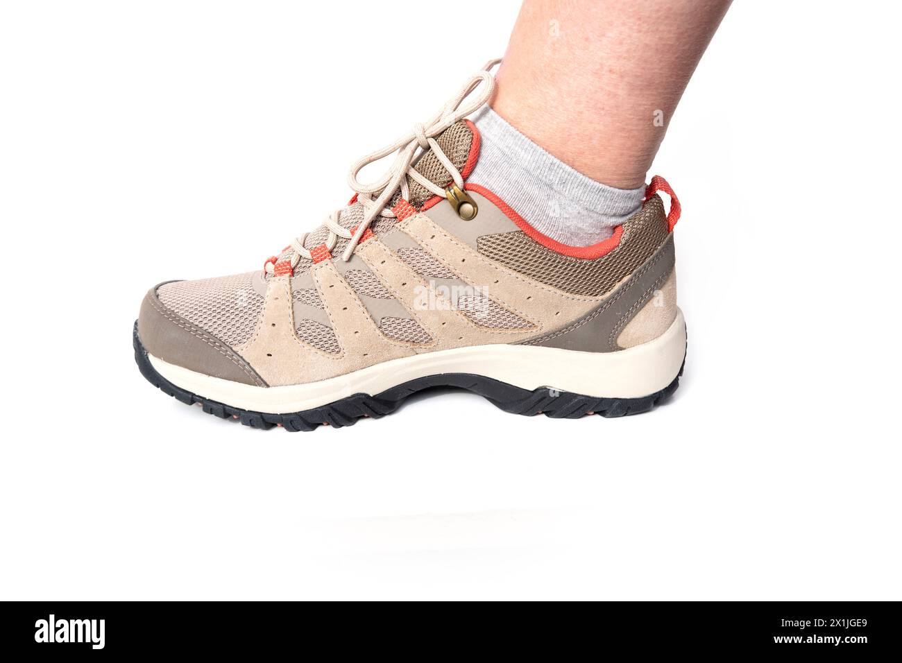 Beige bequeme braune neue Trekking-Sneakers, wasserdichte Wanderschuhe mit Schnürsenkeln, bequeme Schuhe am weiblichen Fuß, versuchen, neue Schuhe kaufen, modern Stockfoto