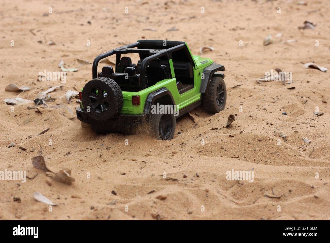 Grüner 4x4 Mini-Jeep rubicon Spielzeugauto mit Fernbedienung, das in Sanddünen fährt Stockfoto
