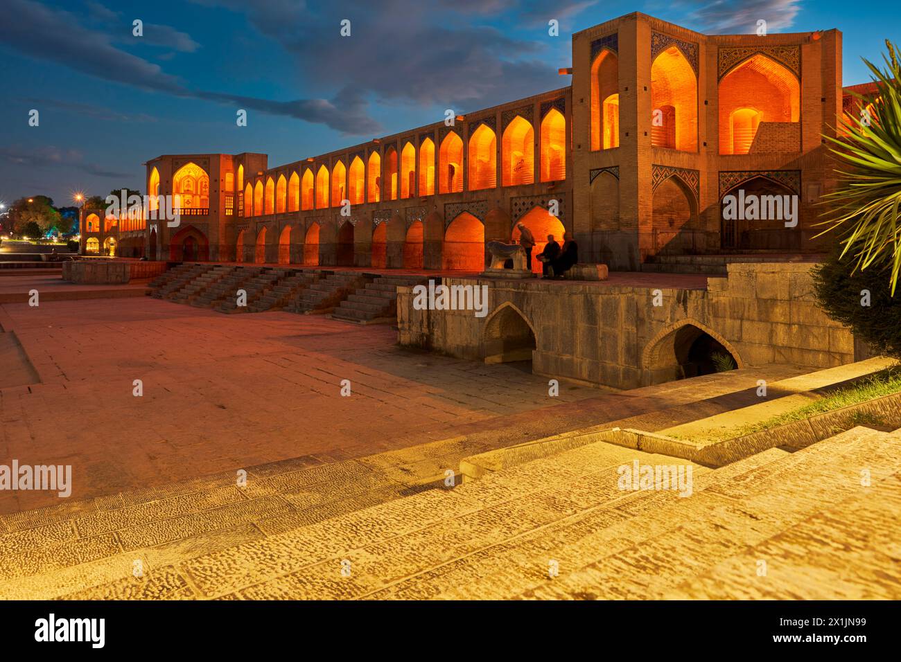 Blick auf die beleuchtete Khaju-Brücke aus dem 17. Jahrhundert auf dem Fluss Zayanderud während der Trockenzeit mit trockenem Flussbett. Isfahan, Iran. Stockfoto
