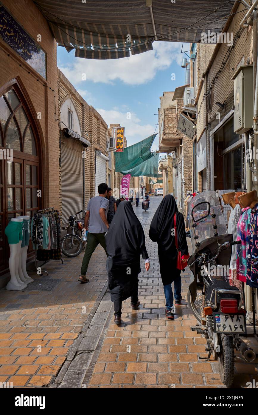 Die Menschen laufen in einer engen Kopfsteinpflasterstraße im historischen Zentrum von Isfahan, Iran. Stockfoto
