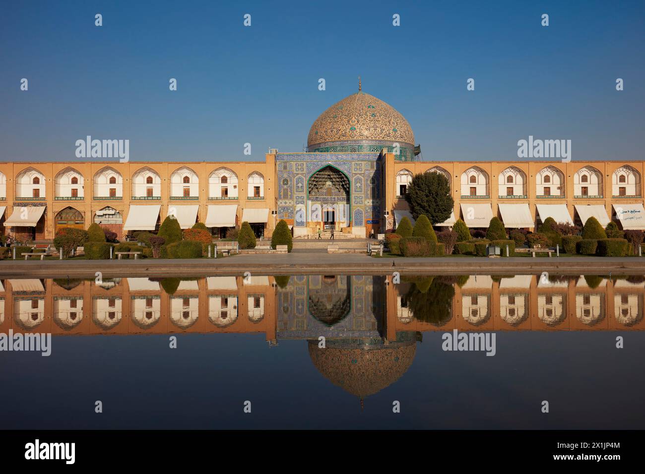 Frontalansicht der Lotfollah-Moschee, die sich in einem Wasserbecken spiegelt. Naqsh-e Jahan-Platz, Isfahan, Iran. Stockfoto