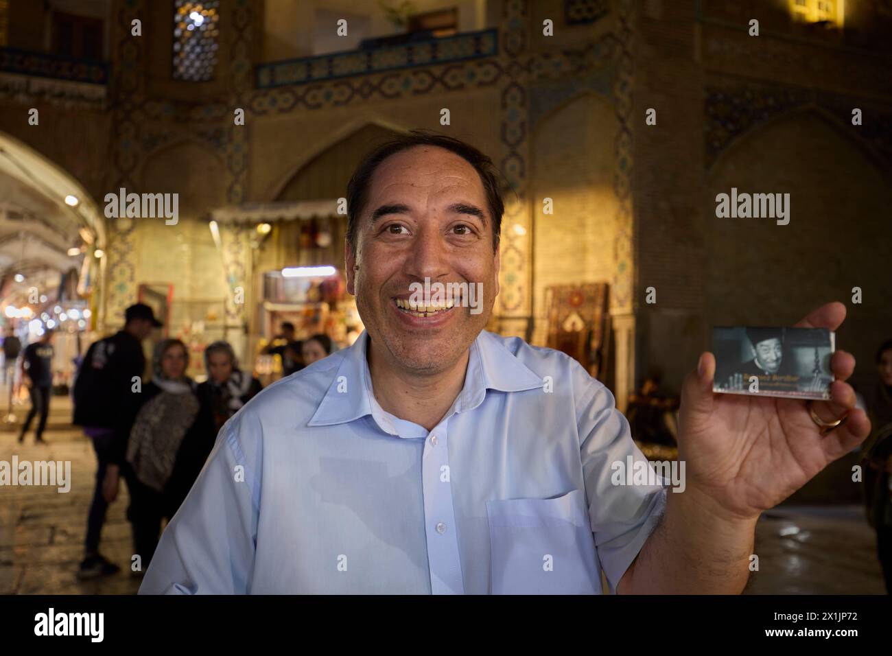 Der grinsende iranische Mann zeigt ein Bild des einst beliebten französischen Comic-Schauspielers Fernandel (Fernand Contandin), um zu beweisen, dass er sich sehr ähnlich sieht. Isfahan, Iran. Stockfoto